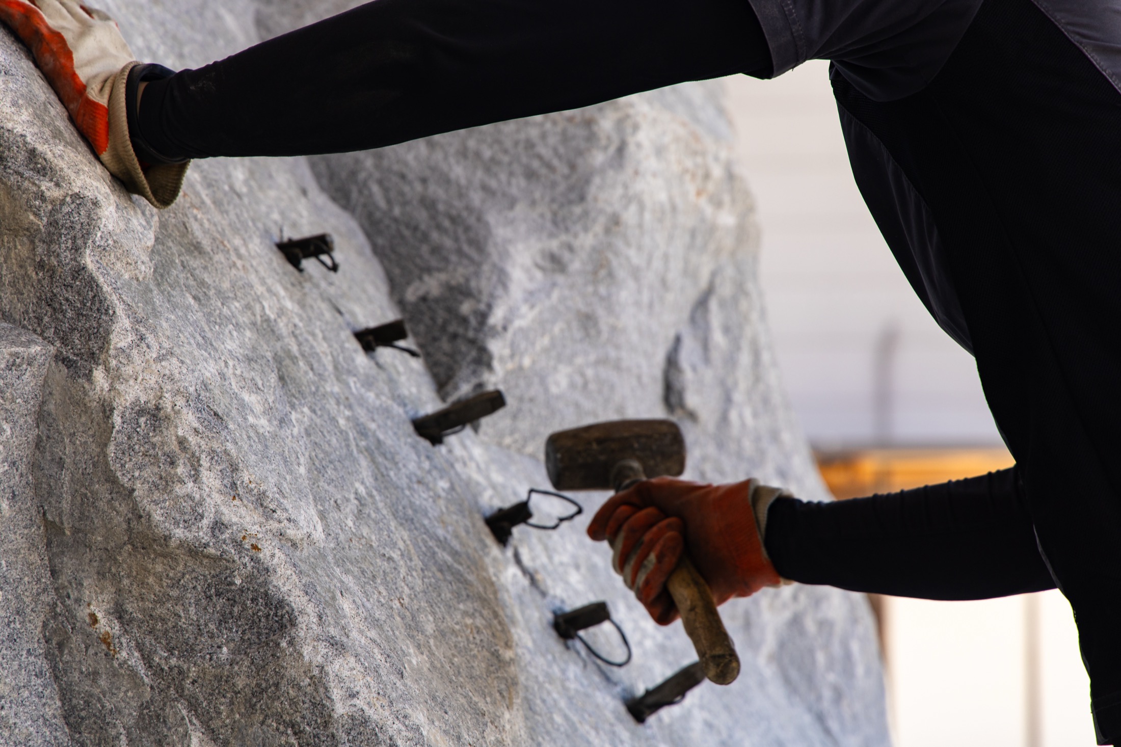 A craftsperson working with wedges, one of the skills connecting material and fabrication.